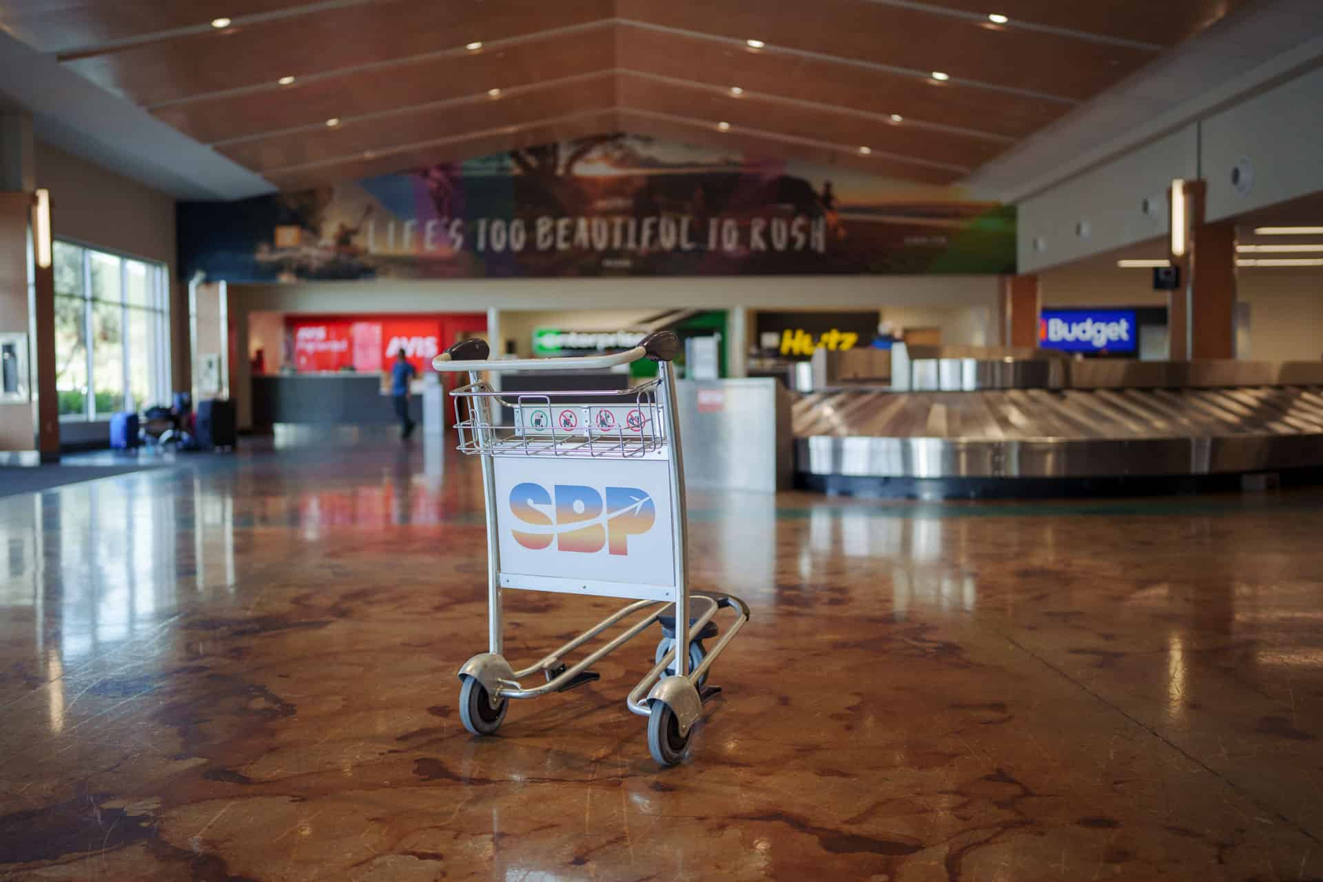SBP branded luggage cart in baggage claim area