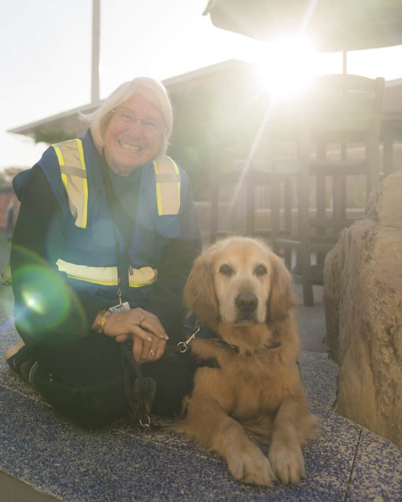 Therapy dog with handler at SLO County Airport (SBP) with sunny background.