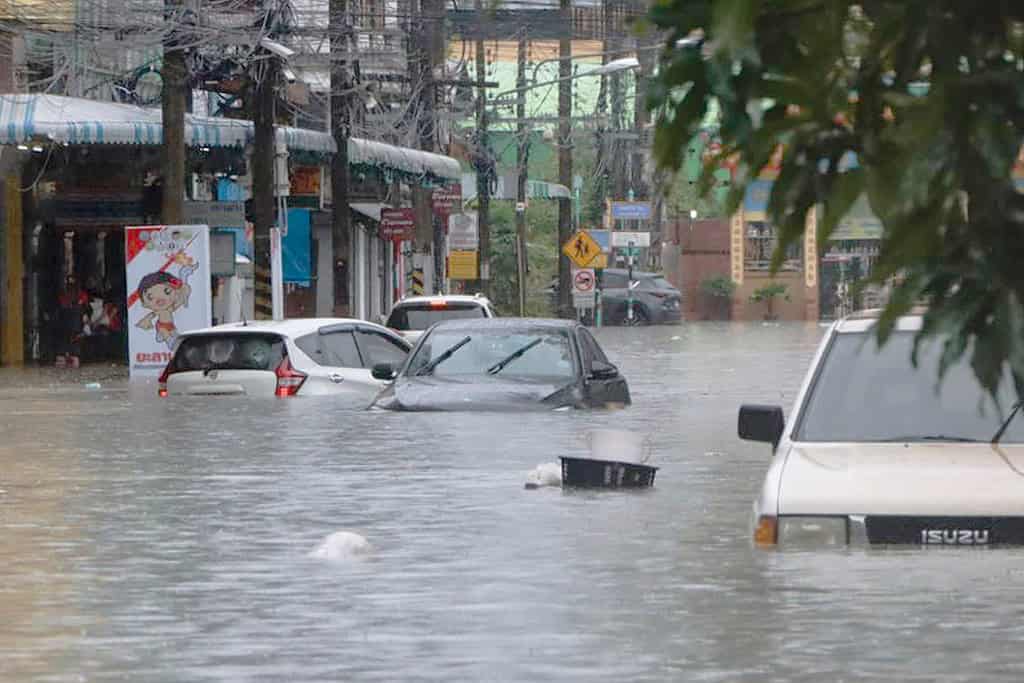 Flooded street with cars during heavy rain in Thailand.