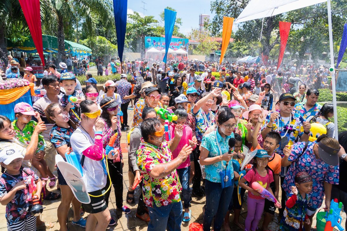 People celebrating Songkran Festival in Hua Hin with water splashing and traditional activities.