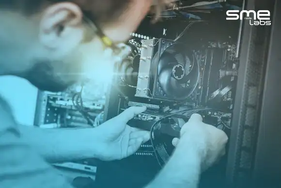 Hands fitting hardware into an open desktop tower, with SMEnode Labs cyan fading in from the bottom-left corner.