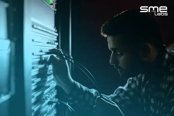 Technician working on network server with cables in a data centre.