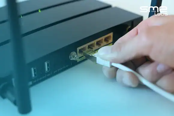 Person connecting Ethernet cable to a network device for DHCP configuration.