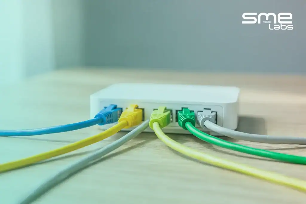 Four coloured Ethernet cables fanning out from a router, representing MikroTik NAT types