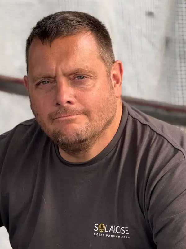 Close-up of a confident man wearing a SOLA OSE Solar Panel Paver shirt, representing solar energy and renewable power solutions.