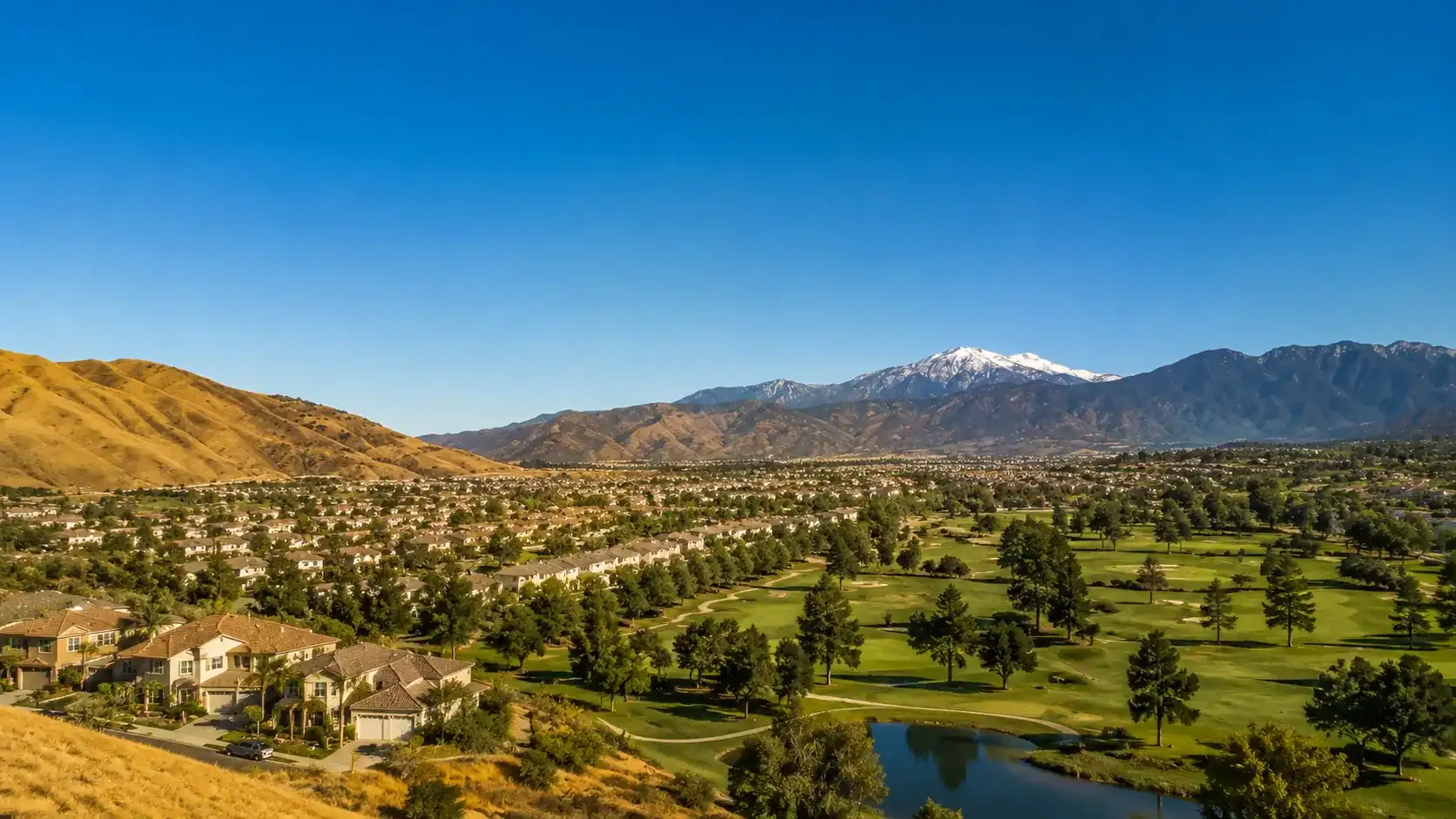 Beautiful panoramic view of Yucaipa golf course with mountains in the background, clear blue sky, and lush green landscape in Yucaipa, CA.