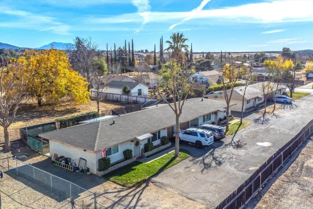 Single-story master home in Yucaipa, CA with a spacious yard, parking area, and surrounding trees, ideal for buyers interested in new construction homes.