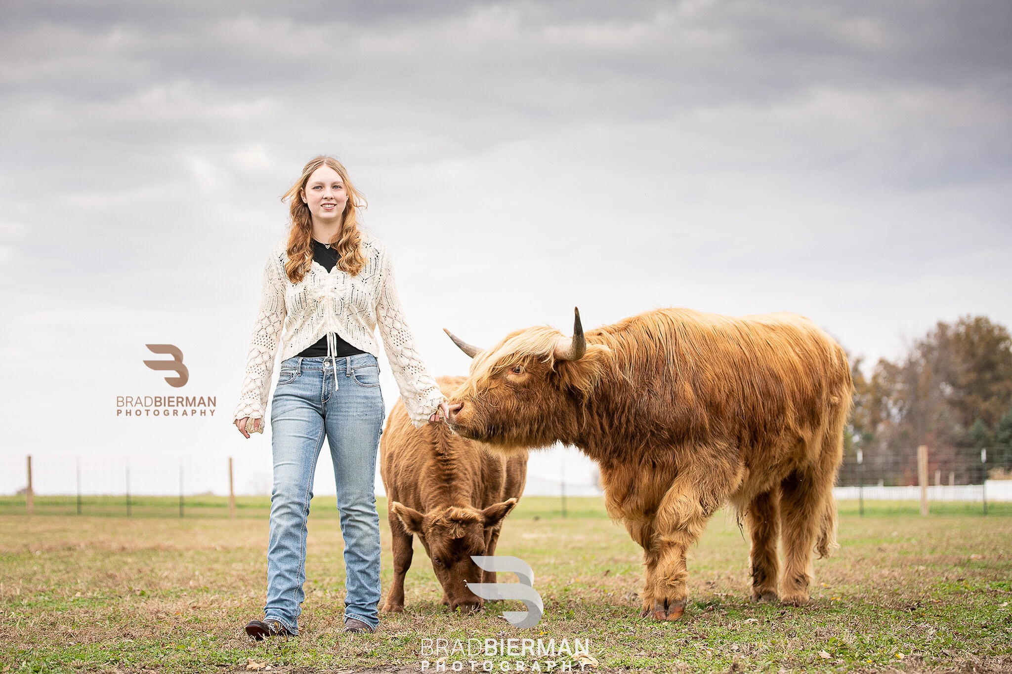 Senior portrait of Iz Snyder, Columbia High School senior, smiling with her bull Butters on her family farm in St. Louis, Missouri