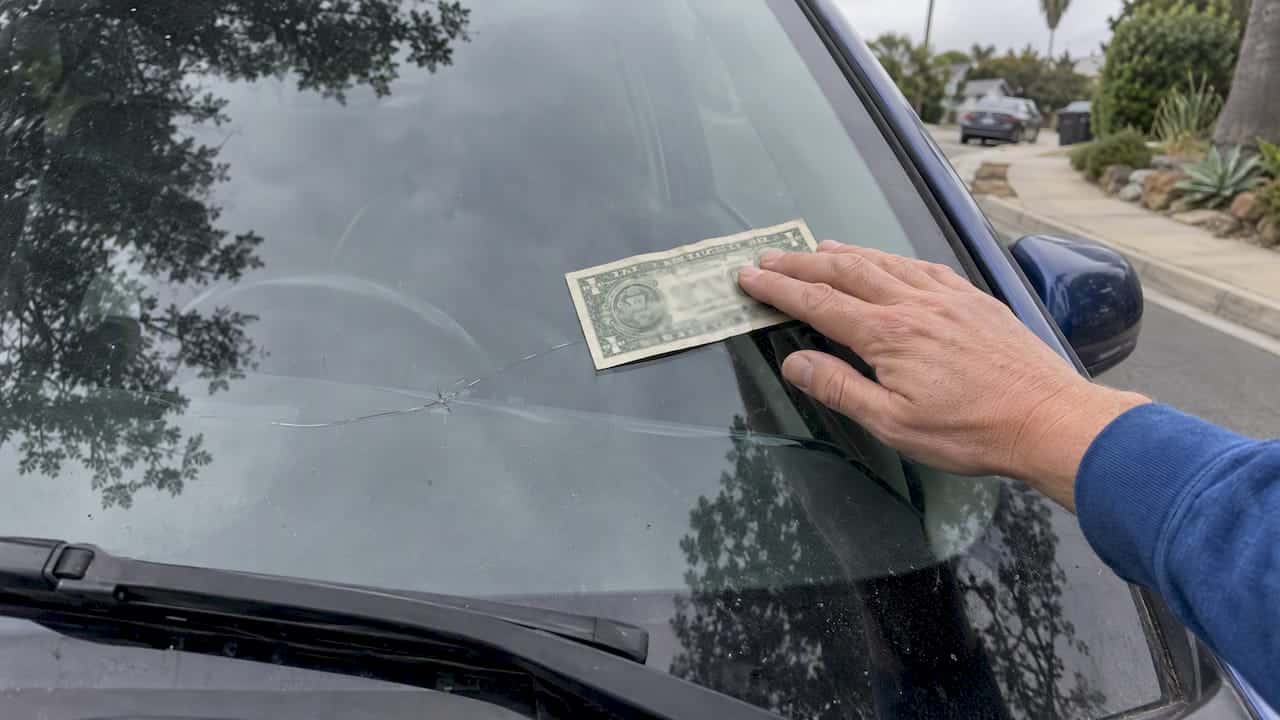 Dollar bill measuring a windshield crack