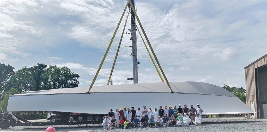 Large yacht hull lifted by crane with Spencer Marine crew below