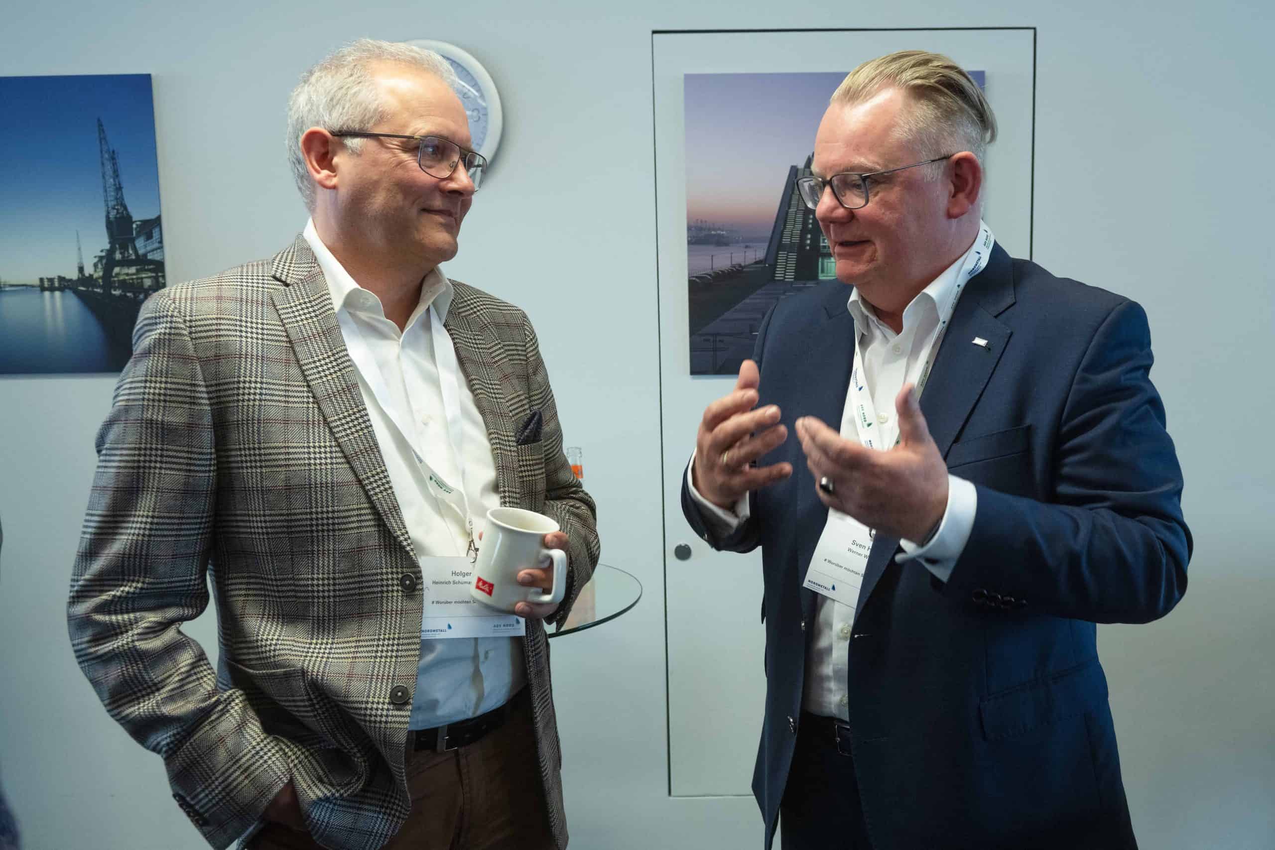 Zwei Männer im Gespräch bei einer Veranstaltung, Business-Meeting, Networking.