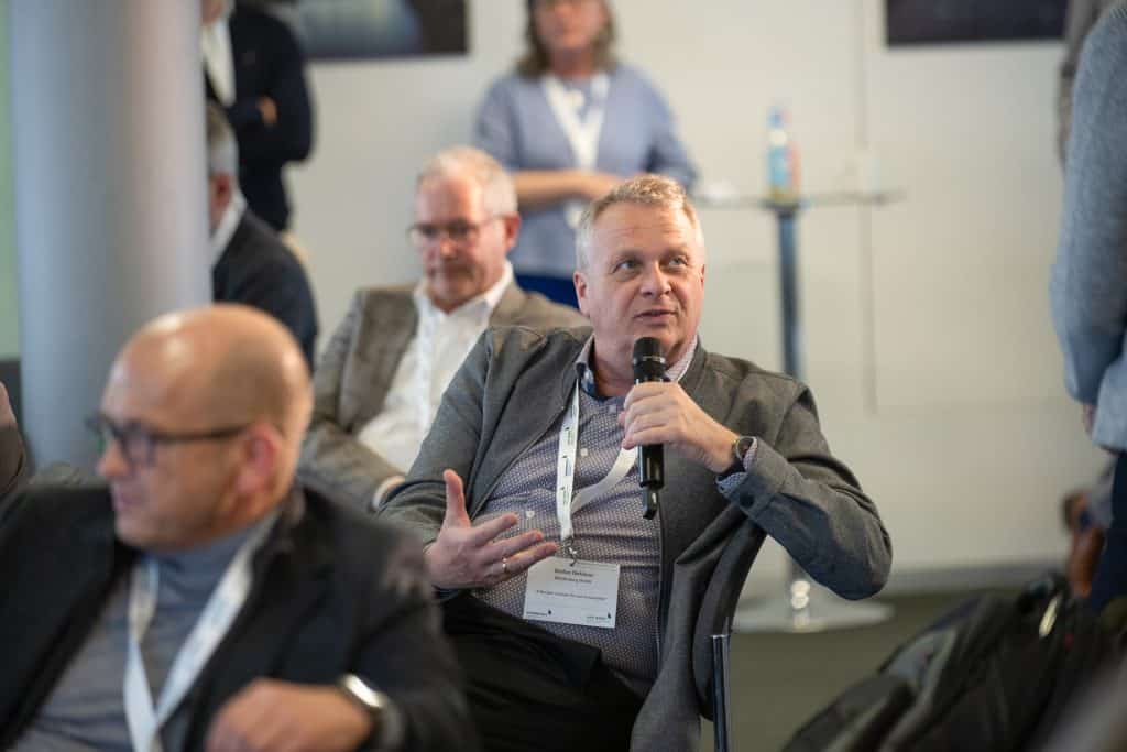Teilnehmer bei einer Konferenz stellt Fragen während einer Session.