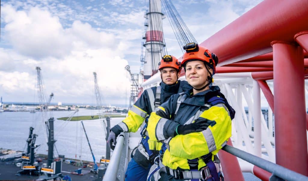 Zwei Feuerwehrleute in voller Ausrüstung auf einem Schiff.