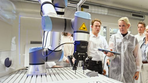 Forschungsgruppe arbeitet mit Robotik und Mikroskopen im Labor.