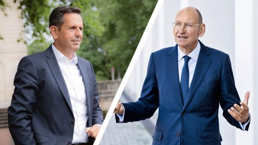 Zwei Männer im Gespräch bei einer Veranstaltung, diskutieren politische Themen.