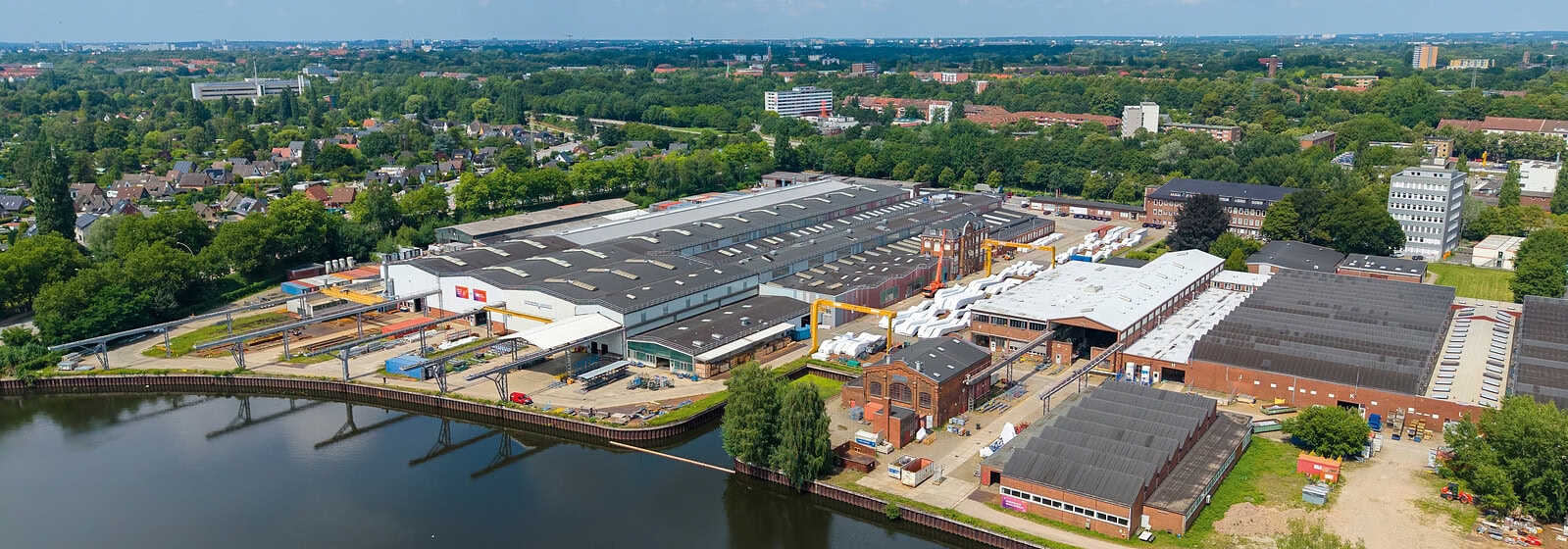 Moderne Hightech-Fabrik in Hamburg mit Wasserfront und Industrieanlagen.