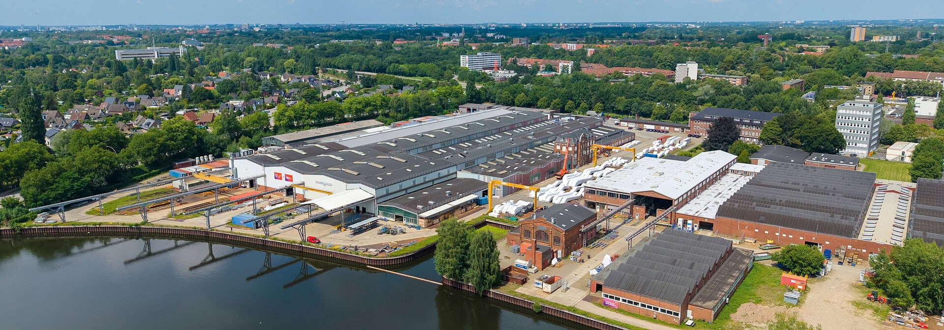 Moderne Hightech-Fabrik in Hamburg mit Wasserfront und Industrieanlagen.