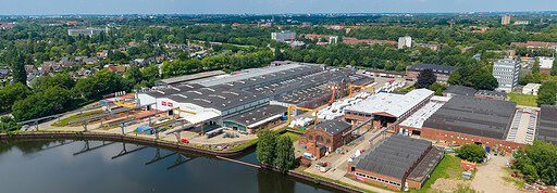 Moderne Hightech-Fabrik in Hamburg mit Wasserfront und Industrieanlagen.