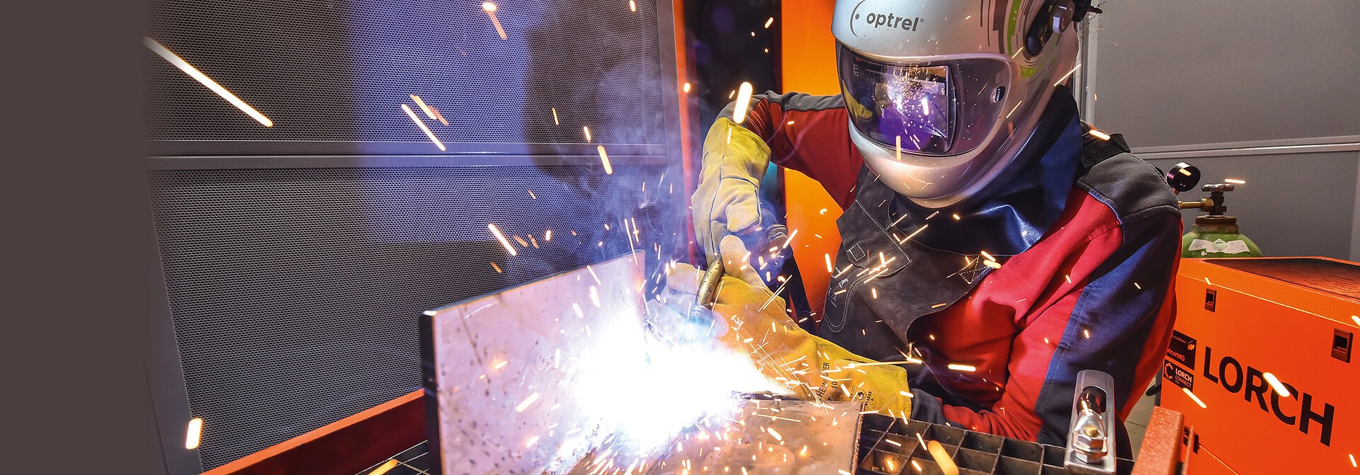 Schweißer bei der Arbeit mit Schutzhelm und -handschuhen in der Norddeutschen Schweißtechnik.