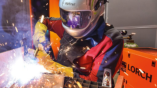 Schweißer bei der Arbeit mit Schutzhelm und -handschuhen in der Norddeutschen Schweißtechnik.