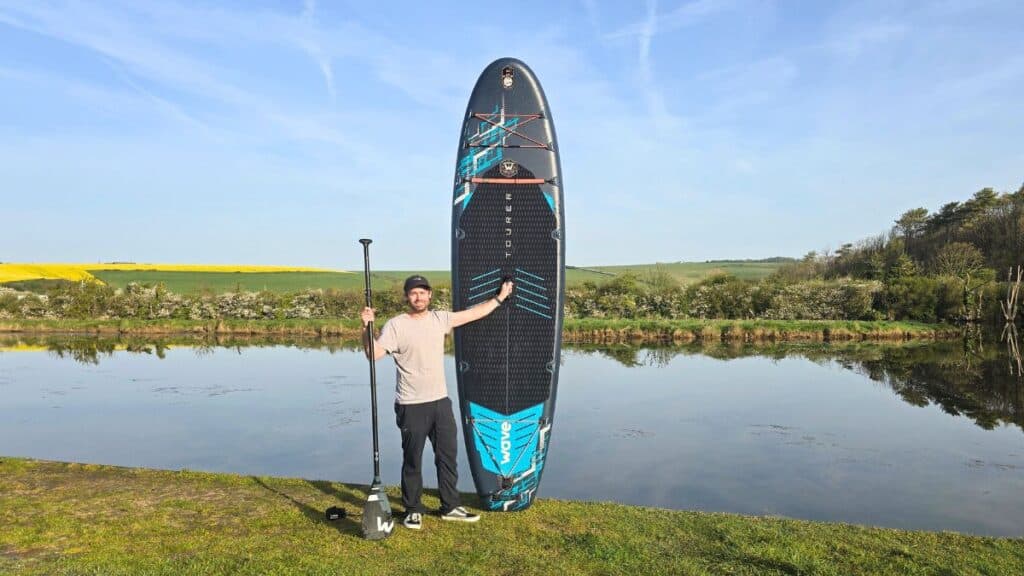 Best Paddle Board for Beginners UK: 8 Top SUPs Compared (2026) 6 Wave Tourer 3.0 Paddleboard Steve stood with board