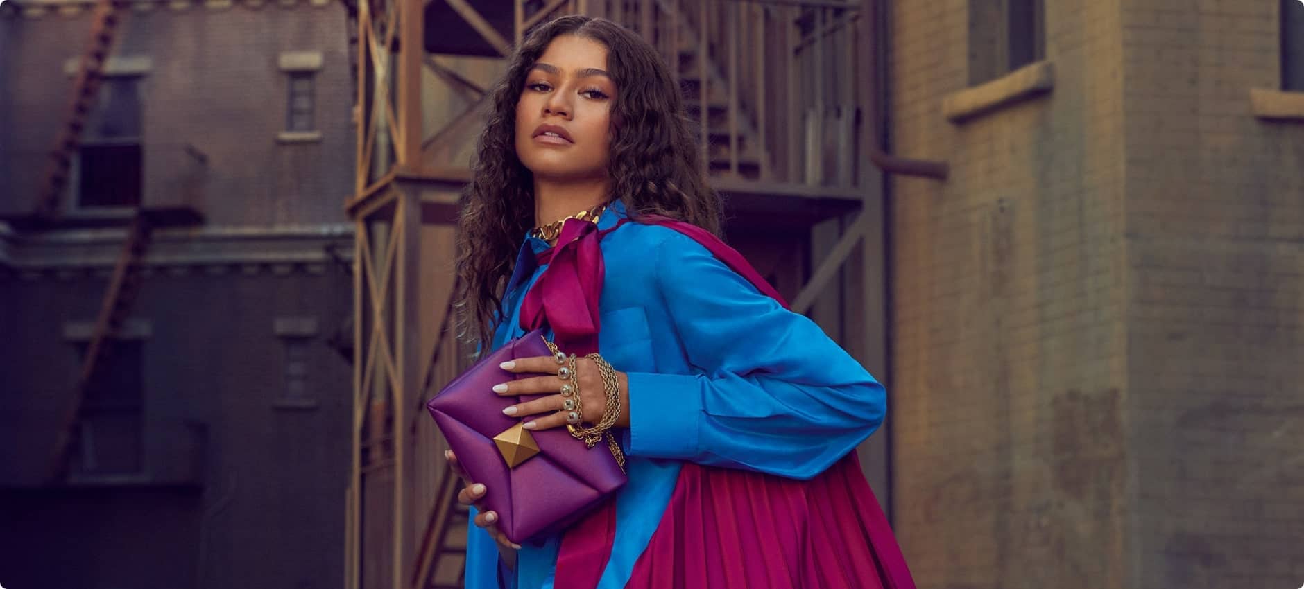 Elegant woman in colorful fashion, urban background, stylish accessories and vibrant clothing.