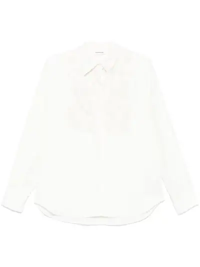 Camisa branca de mulher com detalhes decorativos delicados e estilo elegante.