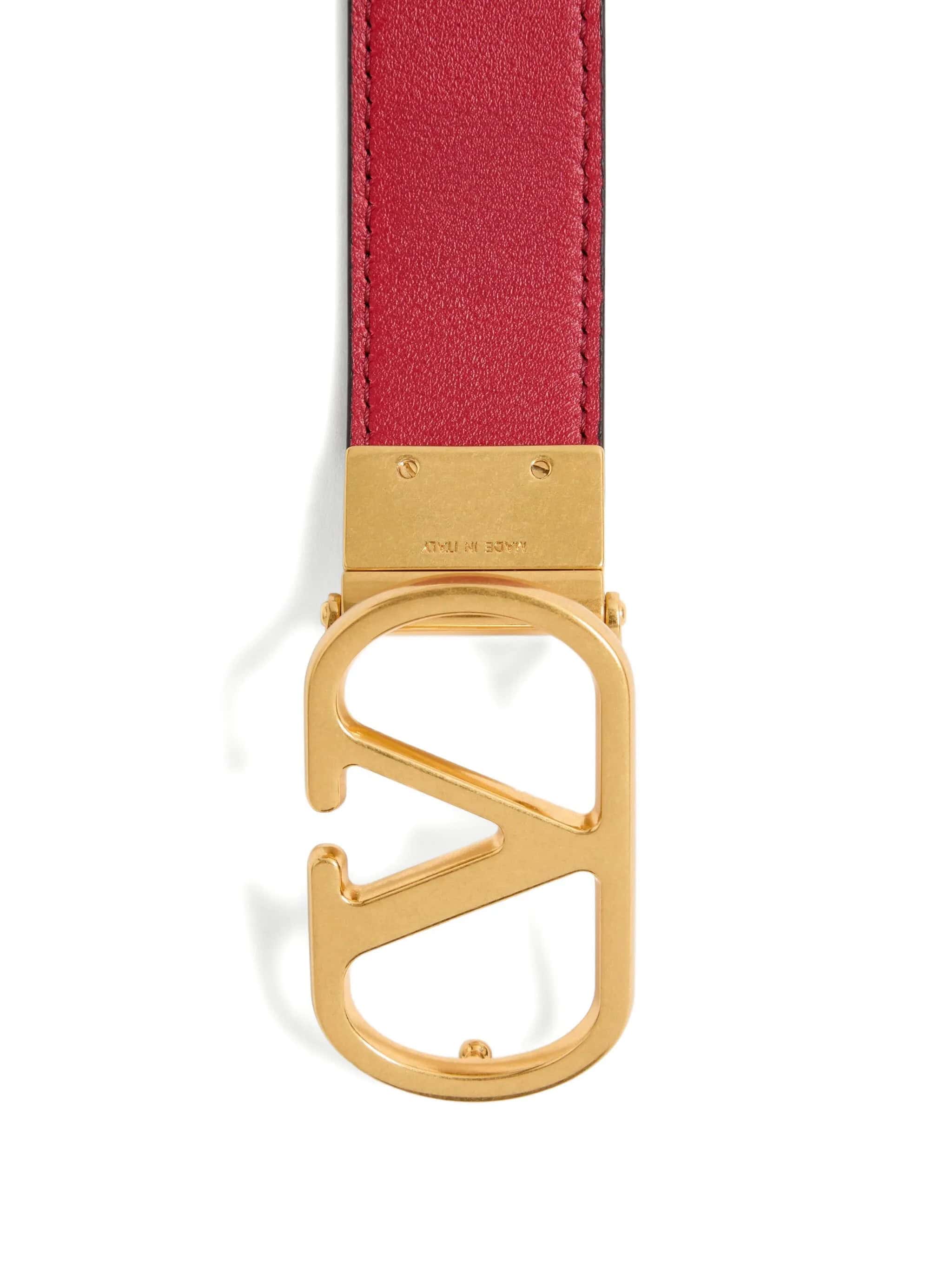 Cinto de couro vermelho com fivela dourada com logo "F".