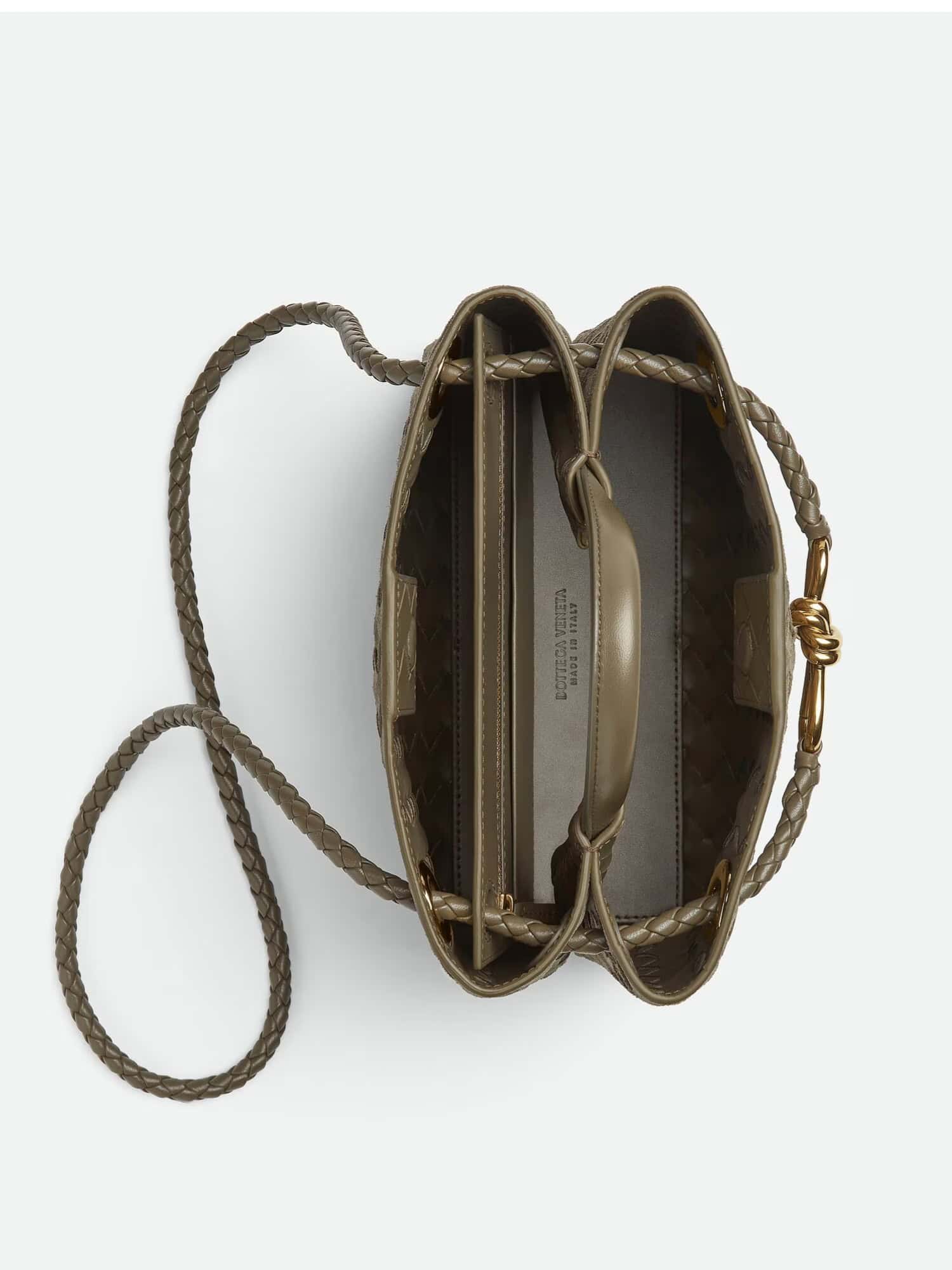 Chic bolsa de couro com detalhes trançados e alças douradas, ideal para moda feminina e masculina.