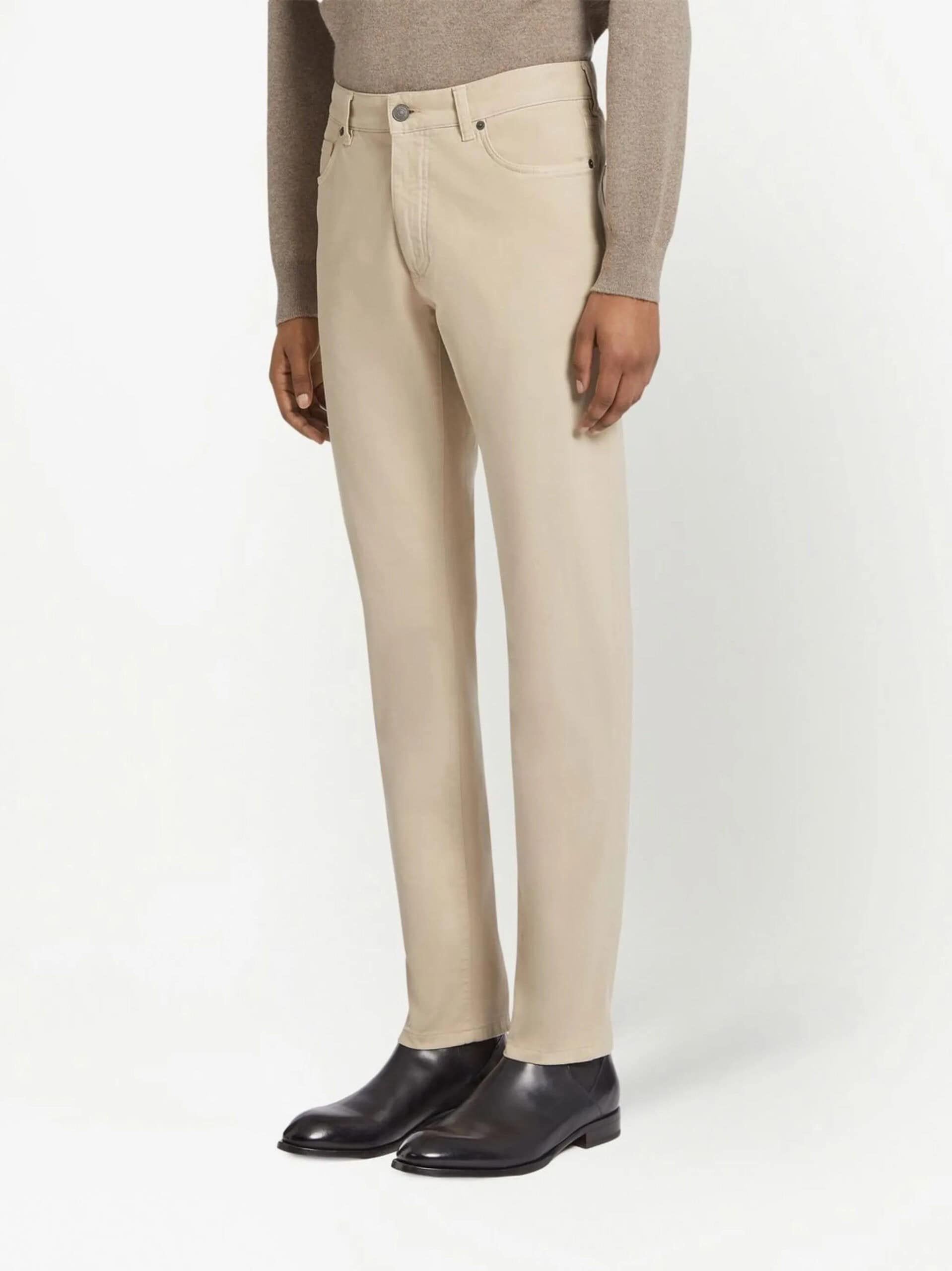 Casual beige straight-leg pants with black leather boots for women, stylish and comfortable.