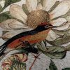 Gedetailleerde foto van een getufte interieurstof met een vogel en bloemmotief, ideaal voor decoratie en meubelstoffen.