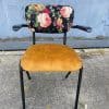 Antieke stoel met stoffenbekleding en bloemenmotief, ideaal voor interieurdecoratie.