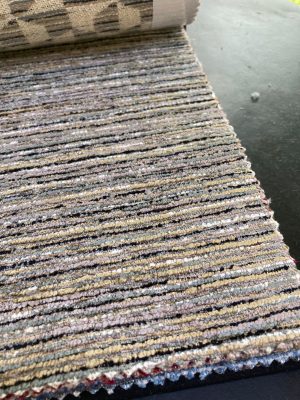 Dichtbij beeld van stoffen met gekleurde lijnen, perfect voor het maken van gordijnen, bekleding en interieurprojecten.