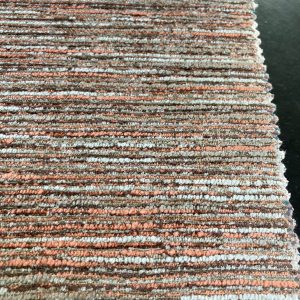 Een close-up van een gebreid interieurstoffencircuit met oranje, beige en grijze tinten, perfect voor meubels en woondecoratie.
