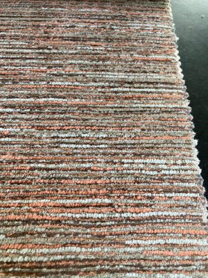 Strepen stoffen. Een close-up van een gebreid interieurstoffencircuit met oranje, beige en grijze tinten, perfect voor meubels en woondecoratie.