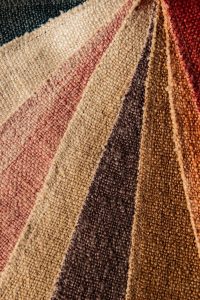 Alt tekst: Diverse textielstalen in aardetinten voor interieurdecoratie en meubelstoffen.