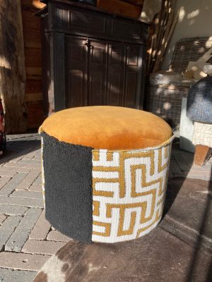 Stijlvolle poef met geometrisch patroon en rijke kleuren. Kunststof en stoffen mix stoel voor woonkamer of slaapkamer.
