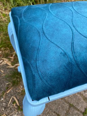 Blauw gestikt stoffenkussen voor stoel, kleurrijk en comfortabel interieurdecoratie.