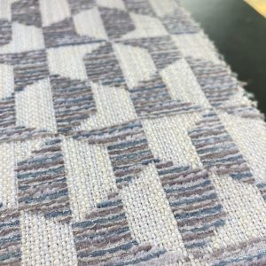 Decoratieve interieurstoffen met geometrisch patroon in neutrale tinten.
