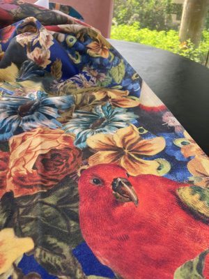 Kleurrijk bloemen en vogel stof met levendige details, ideaal voor interieurdecoratie.