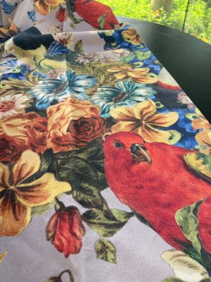 Kleurrijke bloem- en vogelprint stoffencover met levendige details.