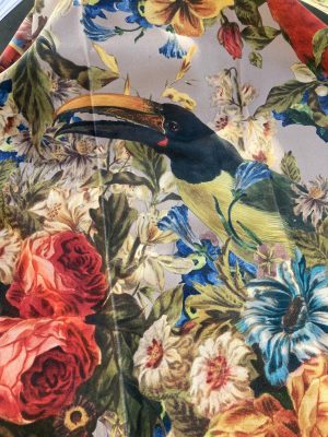 Gevoerde bloemrijke stof met toucan en kleurrijke bloemen, perfect voor interieurdecoratie.