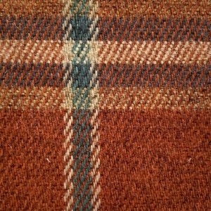 Tweed stof met ruitpatroon in warme tinten, ideaal voor interieurdecoratie en meubelbekleding.