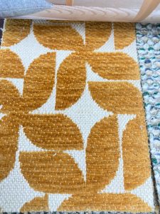 Geometrische patroon vloerkleed met okergele en witte kleuren, ideaal voor woondecoratie en interieur.