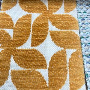 Vintage geometrische interieurstoffen | StoffenBarn. Geometrische patroon vloerkleed met okergele en witte kleuren, ideaal voor woondecoratie en interieur.