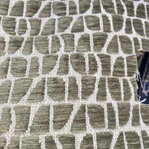 Moderne meubelstof met geometrisch patroon in beige en wit.