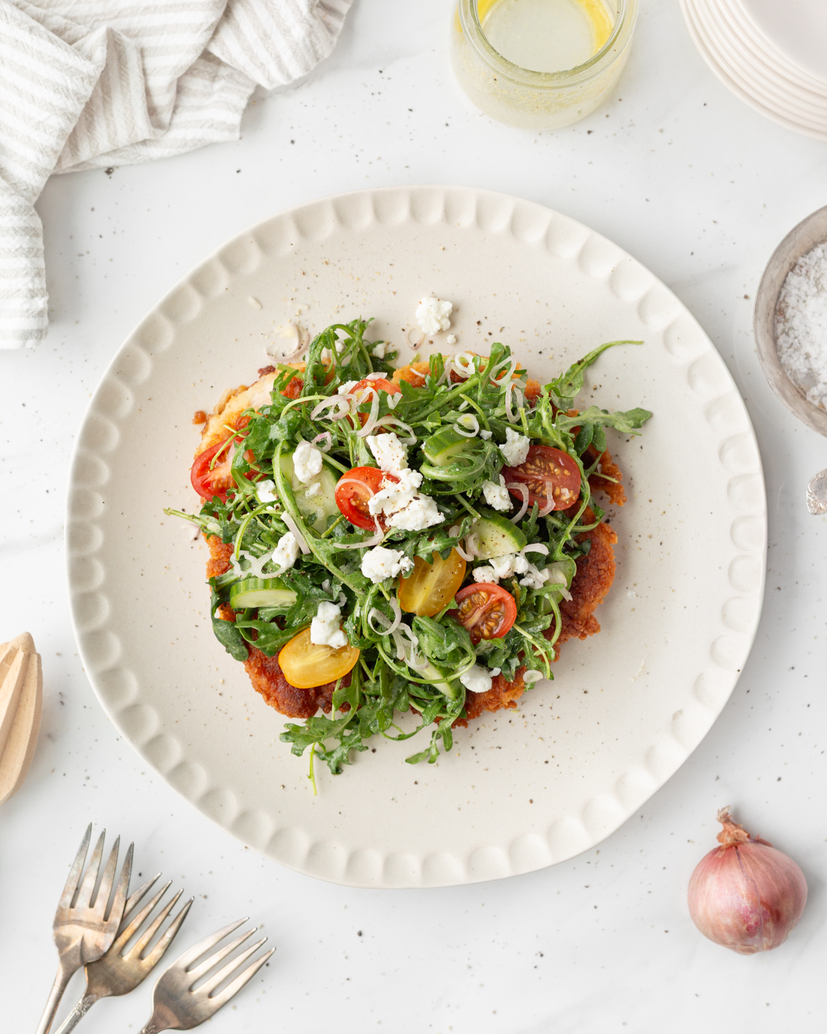 Rocket salad plated and topped with soft goat cheese.