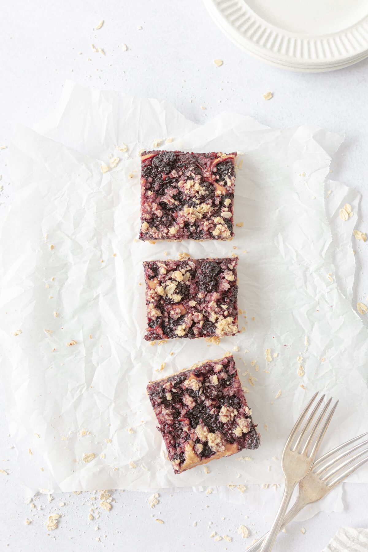 Three Peanut Butter and Jam Breakfast Bars cut on parchment paper.