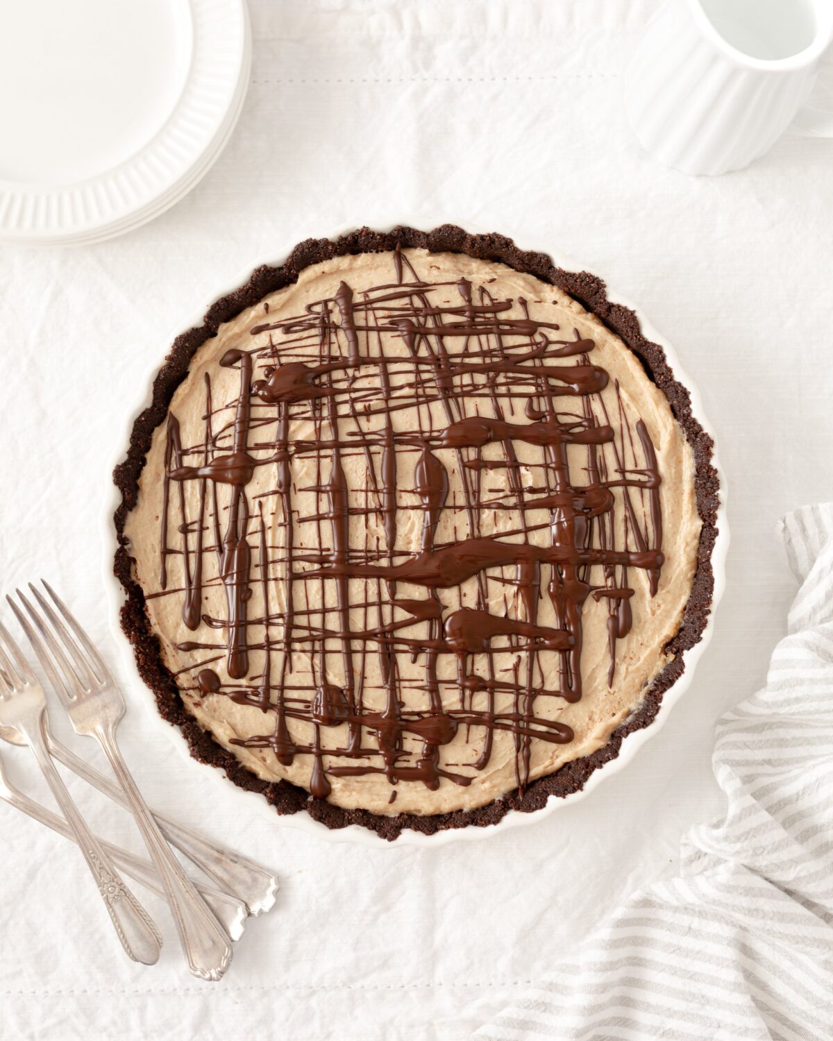 Peanut Butter Pie in a tart pan, topped with chocolate dizzle.