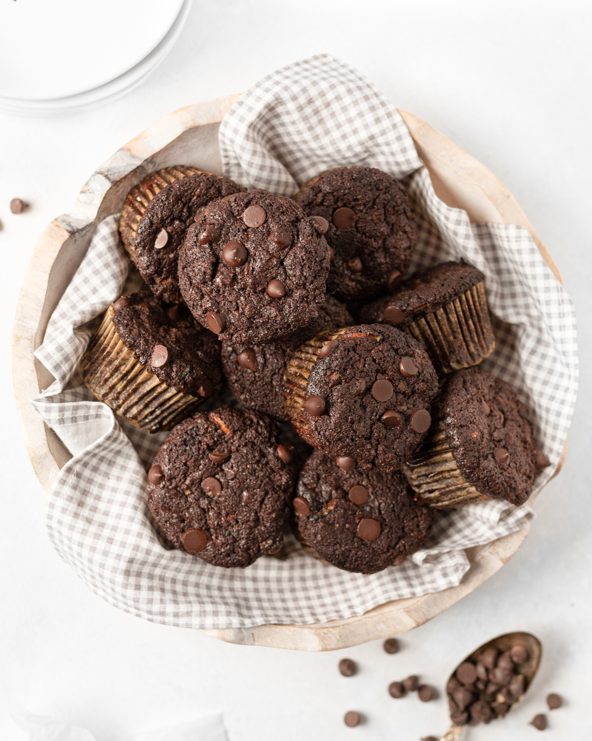 Gluten Free Double Chocolate Zucchini Muffins in a dish towel-lined wooden bowl.